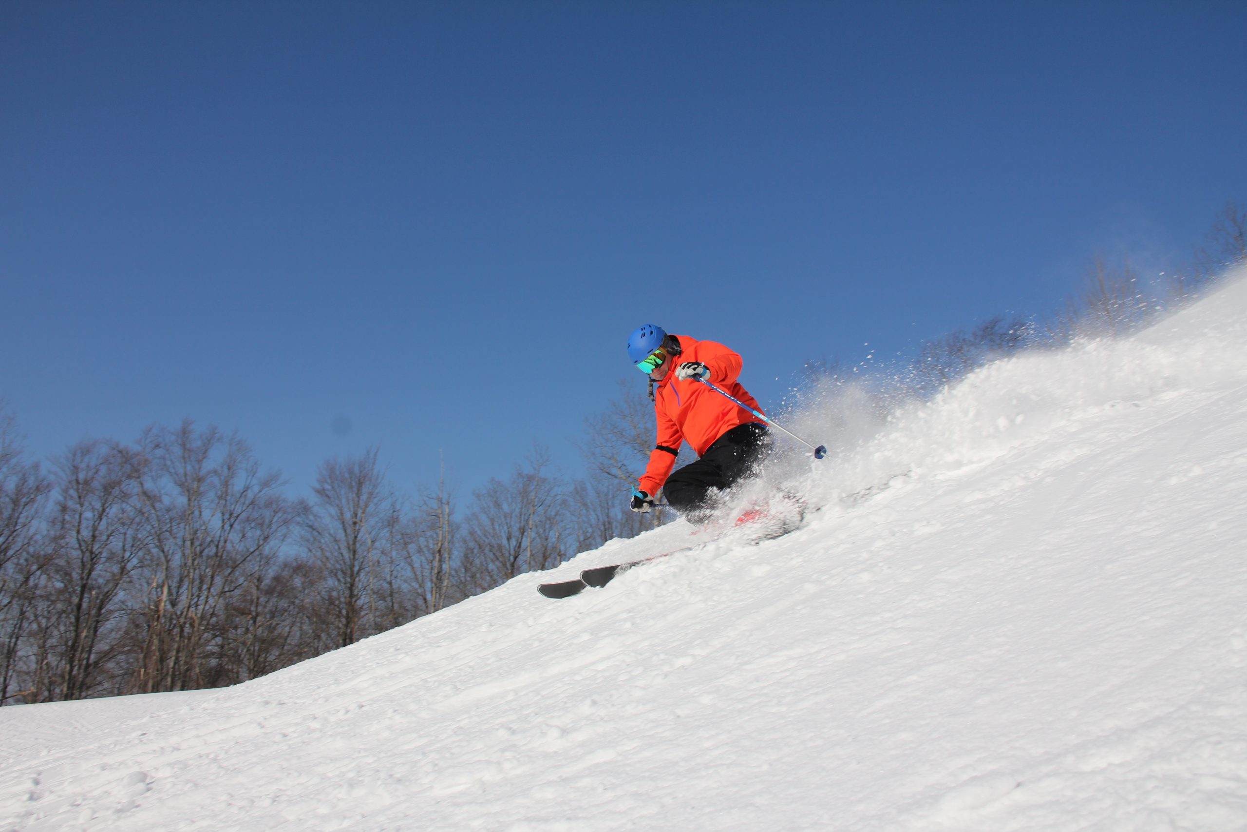 Skier kicking up snow on a turn